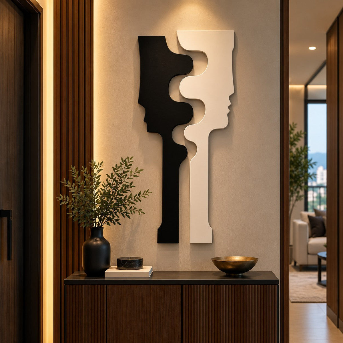 Escultura de pared Art by Amapola con diseño abstracto de dos perfiles enfrentados en blanco y negro sobre pared beige.