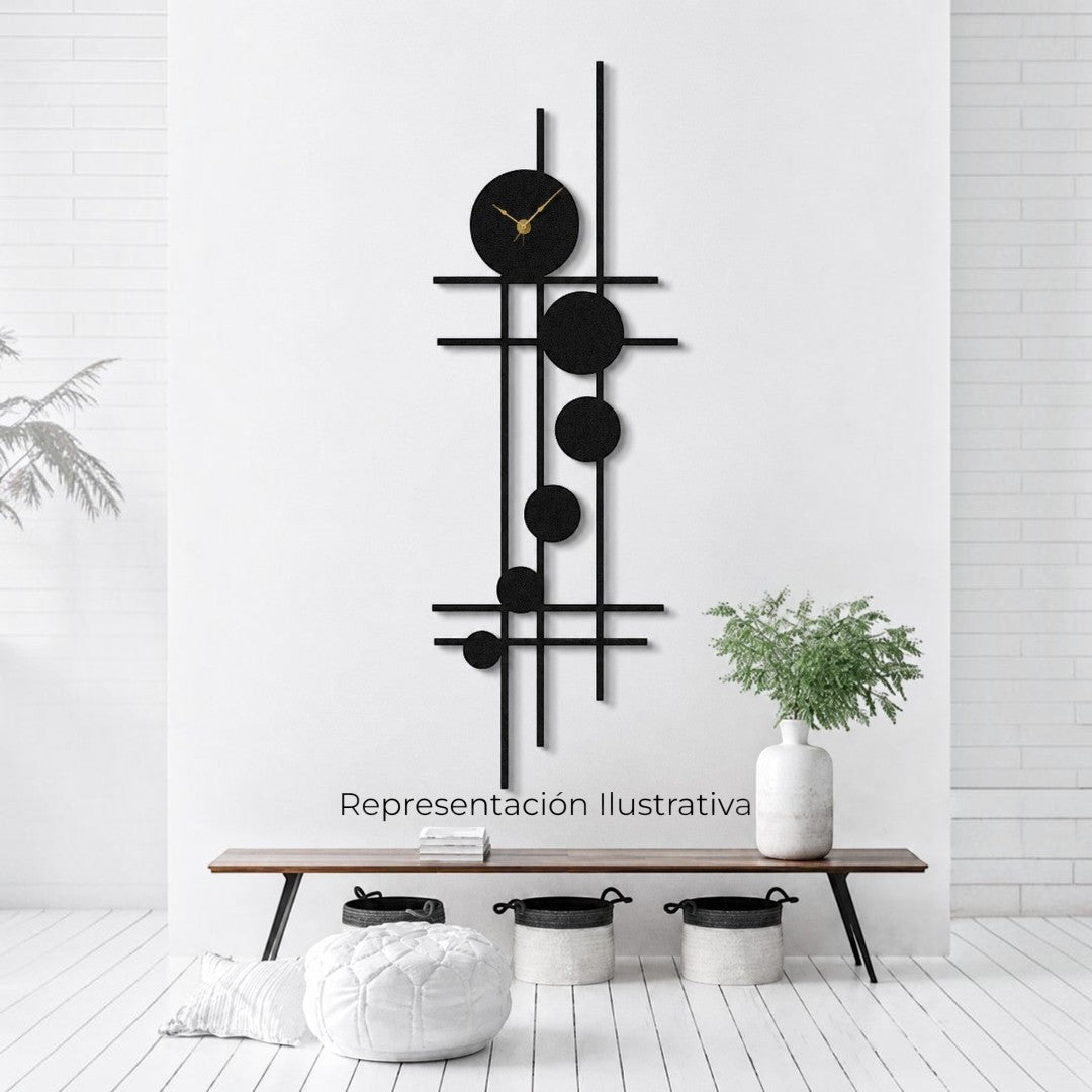 Reloj de pared Art by Amapola con diseño geométrico moderno en metal negro mate y manecillas doradas sobre pared blanca.