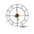 Reloj de pared Art by Amapola de estilo industrial en metal dorado con estructura circular y manecillas negras.